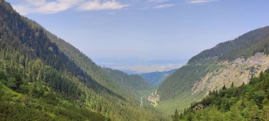 Dağları ve mavi gökyüzü olan güzel bir manzara.