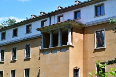 Evin ön cephesinde pencereler ve yeşil yapraklar vardı.