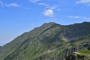 Dağları ve mavi gökyüzü olan güzel bir manzara.