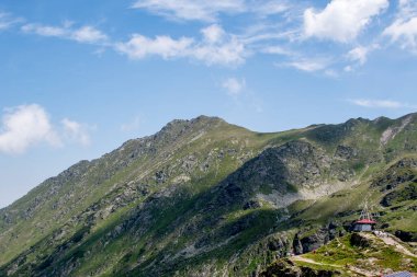 Dağ zirveleri ve bulutları olan güzel bir manzara.
