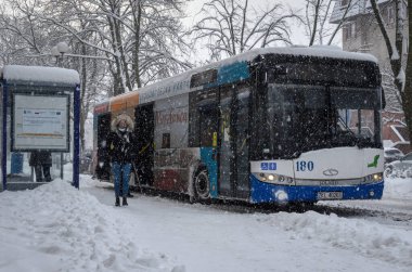 KOLOBRZEG, Batı Pomeranya - POLAND - 2021: Kar üzerinde insanlar ve şehir otobüsü  