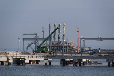 LNG Terminali - Bir gaz terminali inşaatında işçiler ve inşaat makineleri 