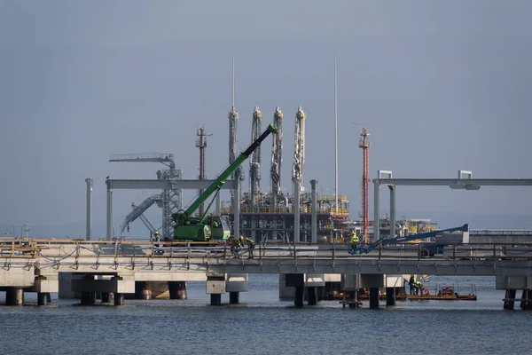 stock image LNG TERMINAL - Workers and construction machinery on a gas terminal building site 