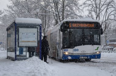 KOLOBRZEG, Batı Pomeranya - POLAND - 2021: Kar üzerinde insanlar ve şehir otobüsü  