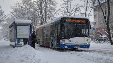 KOLOBRZEG, Batı Pomeranya - POLAND - 2021: Kar üzerinde insanlar ve şehir otobüsü  