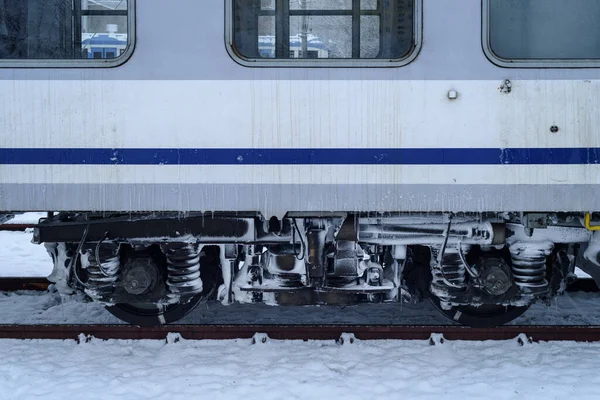 WINTER ON THE RAILWAY - Snow covered and icy wheels of passenger wagons