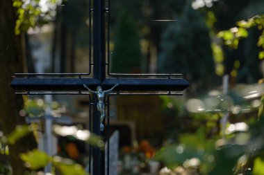 Mezar taşında İsa 'nın heykeli olan çelik bir haç.