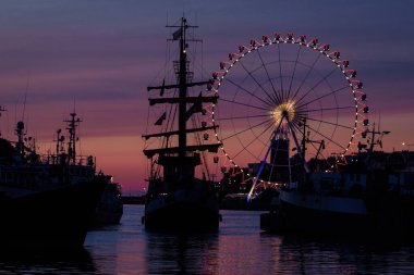 KOLOBRZEG, Batı Pomeranya - POLAND - 09 Temmuz 2023: Akşam karanlığında limandaki küçük bir turizm gemisi 