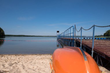 Gölün kıyısında yüzen su kurtarma botu.