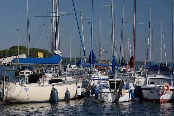 CZAPLINEK, Batı Pomeranya - POLAND - 14 Haziran 2024: Göl kenarındaki LANDSCAPE - marinaya demirlemiş bir yelkenli ve motor yatları