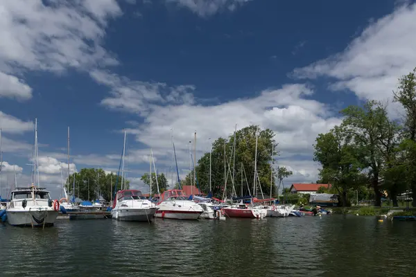 stock image CZAPLINEK, WEST POMERANIAN - POLAND - JUNE 14, 2024: LANDSCAPE BY THE LAKE - A sailboats and motor yachts moored in the marina