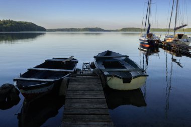STARE DRAWSKO, Batı Pomeranya - POLAND - 14 Haziran 2024: Göl kenarındaki Landscape - Gölde küçük eski kayıklar ve yelkenliler
