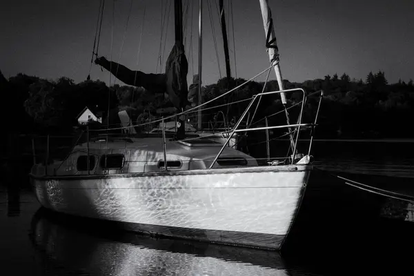 stock image LANDSCAPE BY THE LAKE - A sailboats moored in marina in the rays of the morning sun