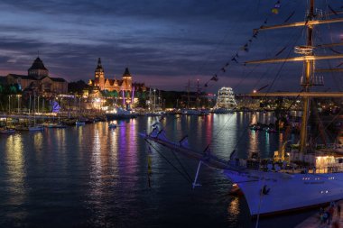 SZCZECIN, WEST POMERANIAN - POLAND - AUGUST 02, 2024: Tall Ship Races - Polish Frigate Dar Mlodziezy, yachts and other sailing ships at representative quais of the sea port  clipart