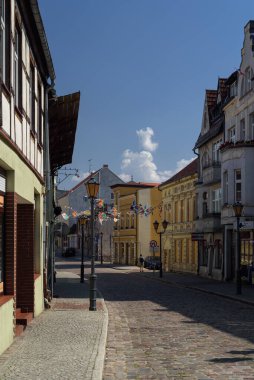 POLCZYN ZDROJ, WEST POMERANIAN - POLAND - 2022: Old picturesque townhouses in sunlight with townspeople in the street clipart