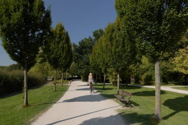 SZCZZZECINEK CITYSCAPE - Gölün kenarındaki parkta bisiklet süren bir kadın