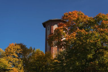 AUTUMN in CITY - Renkli ağaçların arka planına karşı tarihi bir su kulesi