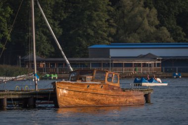 MARINA AT THE LAKE - Classic wooden motorboat at the pier in Szczecinek clipart