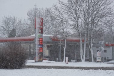 KOLOBRZEG, Batı Pomeranya - POLAND - 11 HAZİRAN 2025 Kışları Şehirde SNOWY Kış- Kentsel bir manzaradaki benzin istasyonu