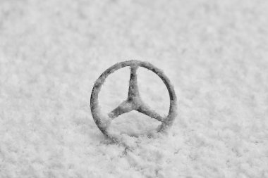 KOLOBRZEG, WEST POMERANIAN - POLAND - JANUARY 11, 2025: MERCEDES brand sign on a snow-covered vehicle clipart