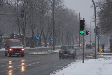 Şehre Kar Düşüşü - Islak sokak yüzeyinde araç ve kavşaktaki trafik ışığı