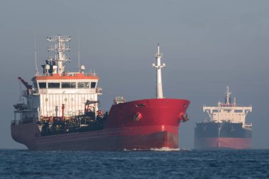 OIL-CHEMICAL TANKER - A red ship sails along waterway clipart