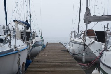 STARE DRAWSKO, BATI POMERANYAN - POLAND - 16 EKİM 2024: KÖLÜNDE LANDSCAPE - Sisli bir günde iskelede bir yelkenli