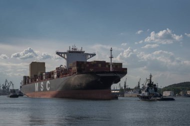 GDYNIA, POMERAN REJON - POLAND - 27 Mayıs 2024: Limandan denize doğru büyük bir konteyner gemisi hareket ediyor