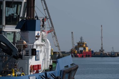 GDYNIA, POMERAN REJON - POLAND - Eylül 09, 2023: Rıhtımda bir römorkör ve arka planda çalışan bir sıkıcı