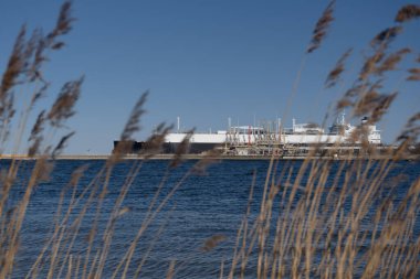 LNG Terminali ve GAS TANKER - Liman iskelesine demirlemiş siyah bir gemi