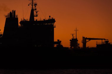SEAPORT üzerinde GÜNEŞ - Gemi deniz fenerinin arka planına karşı limana girer 