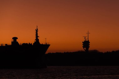 SEAPORT üzerinde GÜNEŞ - Gemi deniz fenerinin arka planına karşı limana girer 