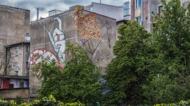 GDYNIA, POMERAN REJON - POLAND - 23 Mayıs 2025: Eski kasaba evleri ve endüstriyel bir duvar resmi