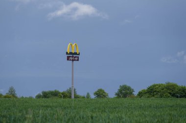 KOLOBRZEG, BATI POLAND - 28 MAYIS 2025: Fast food zincirinin logosu yeşil bir tarlanın ve mavi gökyüzünün arka planında