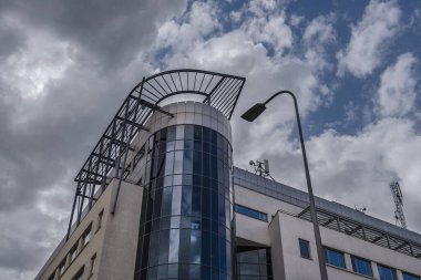 DYNAMIC CITY LANDSCAPE - Gdynia 'da modern bir ofis binası kümülüs bulutlu mavi gökyüzünün arka planına karşı