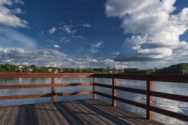 Yaz mevsimi CZAPLNEK 'te güzel güneşli bir gün, göldeki tahta iskelede.