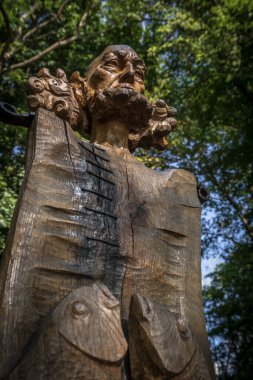 CZAPLINEK, BATI POLAND - 17 Temmuz 2024: Kavak ağacının gövdesine sanatçı Edward Szatkowski tarafından oyulmuş eski bir balıkçı figürü