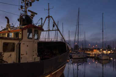 KOLOBRZEG, Batı Pomeranya - POLAND - 20 Temmuz 2025: balıkçı teknesi ve yat üzerinde gün doğumu