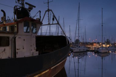 KOLOBRZEG, Batı Pomeranya - POLAND - 20 Temmuz 2025: balıkçı teknesi ve yat üzerinde gün doğumu