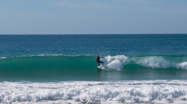 El Palmar sahilinde sörf yapan genç sörfçü. Cadiz 'deki İspanyol Atlantik kıyısı, Avrupa' da mükemmel bir sörf noktası.