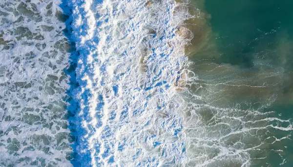 Güney İspanya 'da bir kış akşamı güzel Atlantik dalgaları kopuyor. Sörfçü dalgalar nazikçe kırılıyor