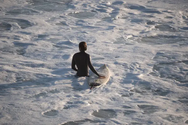 Sörfçü Cadiz, İspanya 'da dalgaları yakalamak için suya giriyor.