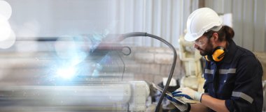 Mühendis robot kaynak makinesi öğretiyor 