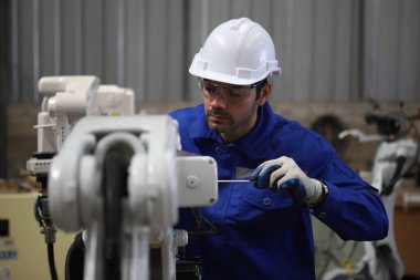 Mühendis robot kaynak makinesi öğretiyor 