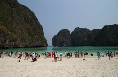 THAILAND, PHI PHI ISLAND, 11 NİSAN 2023 Turistler Maya Körfezi plajında keyif çatıyor ve turkuaz su lagün tropikal plaj tatili, Maya plajı Tayland yazı. 