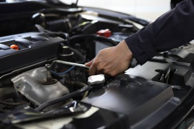 Otomobil tamircisi garajda çalışıyor. Tamir servisi. Motoru kontrol ediyorum.