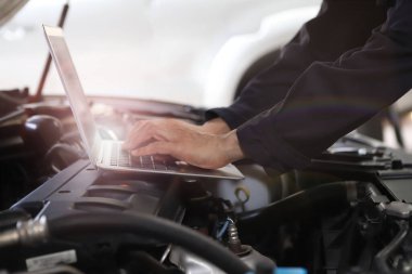 Otomobil tamircisi garajda çalışıyor. Tamir servisi. Motoru kontrol ediyorum.