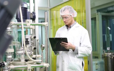 scientist analyzing a biological and ecological hemp plant used for herbal pharmaceutical CBD oil and THC oil in a laboratory.