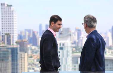 İş adamları. Şehir geçmişi olan bir binada kadın ve erkek iş adamları çalışıyor. 