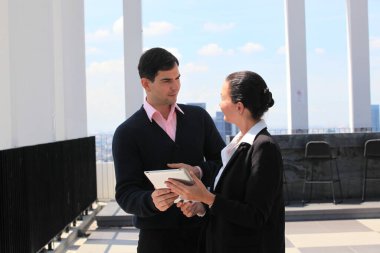 İş adamları. Şehir geçmişi olan bir binada kadın ve erkek iş adamları çalışıyor. 